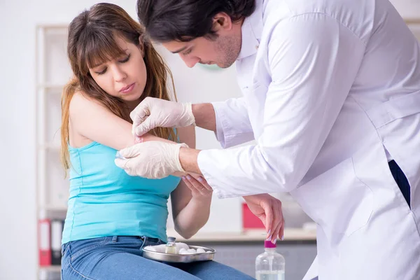 Joven brazo lesionado mujer visitando joven médico traumatólogo — Foto de Stock