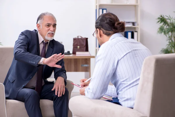 Old man visiting young male doctor psychologist — Stock Photo, Image