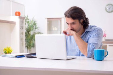 Evde çalışan genç bir erkek.