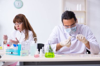 Laboratuvarda çalışan iki kimyager.