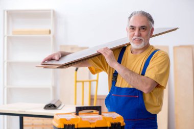 Yaşlı erkek marangoz atölyede çalışıyor.