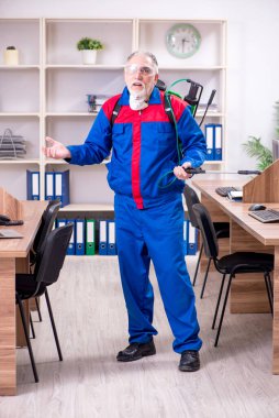 Ofiste haşere kontrolü yapan profesyonel bir müteahhit.