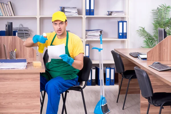 Jonge mannelijke aannemer schoonmaken van het kantoor — Stockfoto