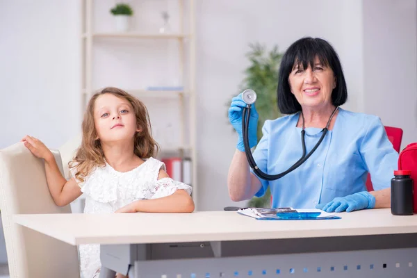 Menina visitando velho médico feminino — Fotografia de Stock