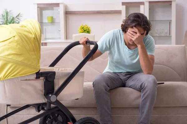 Young man looking after baby in pram — Stock Photo, Image