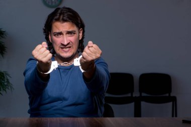 Genç mahkum karanlık odada oturuyor.