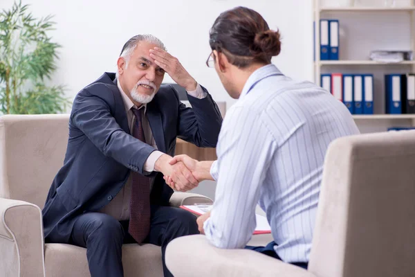 Old man visiting young male doctor psychologist — Stock Photo, Image