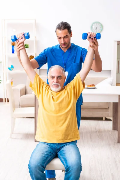 Junger Arzt besucht alte Patientin zu Hause — Stockfoto