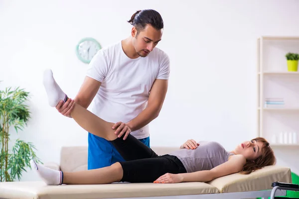 Ung kvinna besöker manlig läkare sjukgymnast — Stockfoto