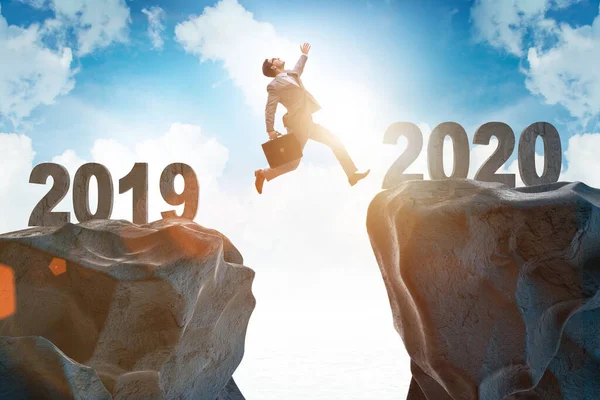 Businessman jumping from year 2019 to 2020 — Stock Photo, Image