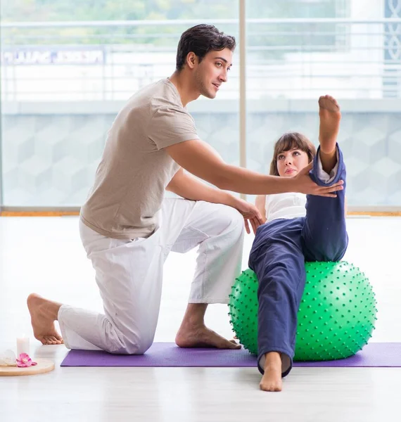 Personal Coach hilft Frau im Fitnessstudio mit Stabilitätsball — Stockfoto