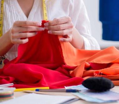 Yeni elbise tasarımları üzerinde çalışan kadın terzi.