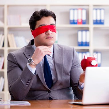 Ofiste masasında oturan gözü bağlı iş adamı.