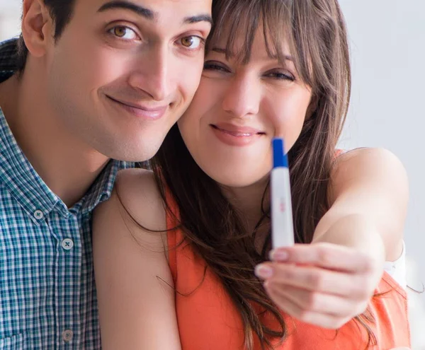 Wife and husband looking at pregnancy test — Stock Photo, Image