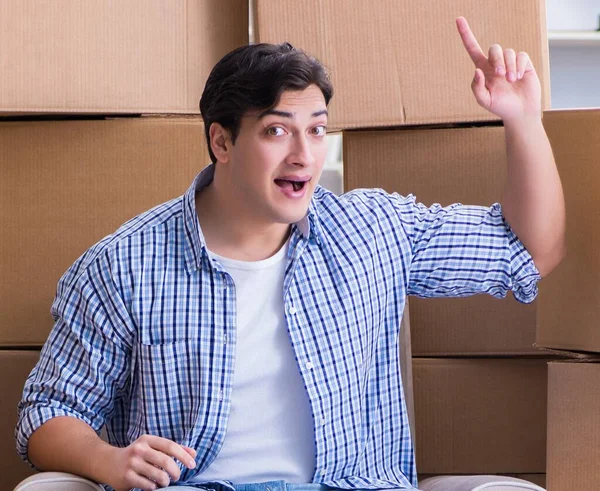 Le jeune homme emménage dans une nouvelle maison avec des boîtes — Photo