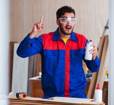 Yooung marangoz boyayla uğraşıyor.