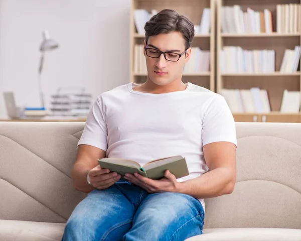 Uomo lettura libro seduto nel divano divano — Foto Stock