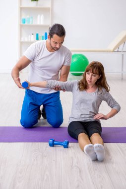 Kişisel koçla spor egzersizleri yapan genç bir kadın.