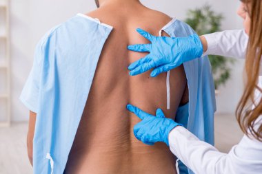 Genç sırtı yaralı bir adam, kadın doktor masörünü ziyaret ediyor.