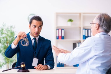 Adliyedeki erkek doktor avukatla toplantıda.