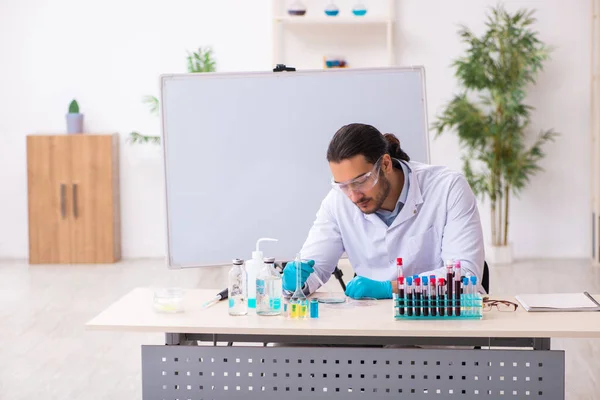 Jovem químico do sexo masculino que trabalha no laboratório — Fotografia de Stock