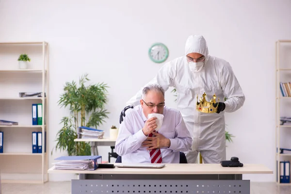 Alter Mitarbeiter fängt sich Coronavirus am Arbeitsplatz ein — Stockfoto