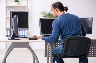 Ofiste çalışan genç bir erkek.