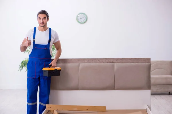 Giovane imprenditore maschio installazione di mobili a casa — Foto Stock