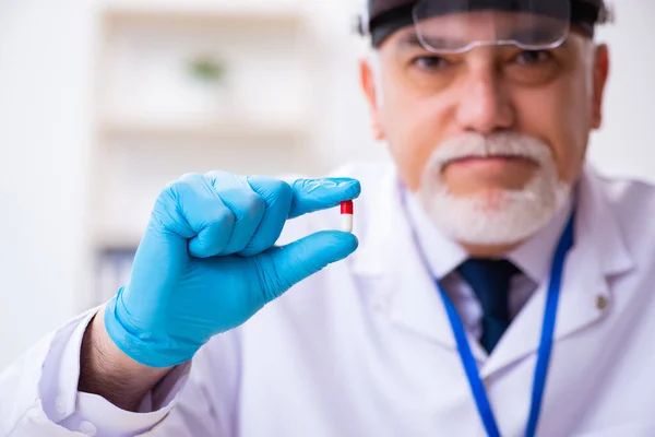 Homem velho criminologista especialista que trabalha no laboratório para provas — Fotografia de Stock