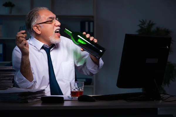 Velho empregado do sexo masculino trabalhando até tarde no escritório — Fotografia de Stock