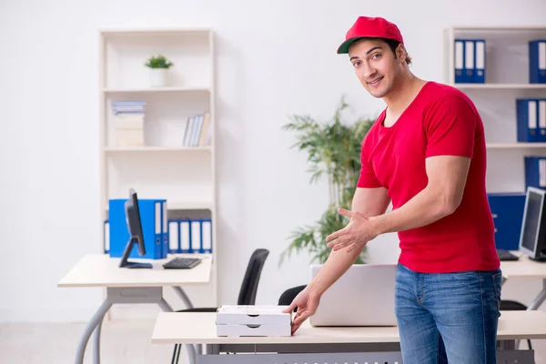 Jovem mensageiro masculino entregando pizza para o escritório — Fotografia de Stock