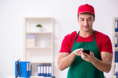 Genç erkek kurye ofise pizza getiriyor.