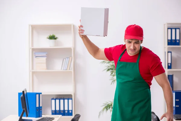 Ung manlig kurir levererar pizza till kontoret — Stockfoto