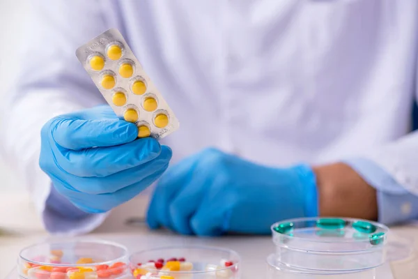 Young male lab assistant in drug synthesis concept — Stock Photo, Image