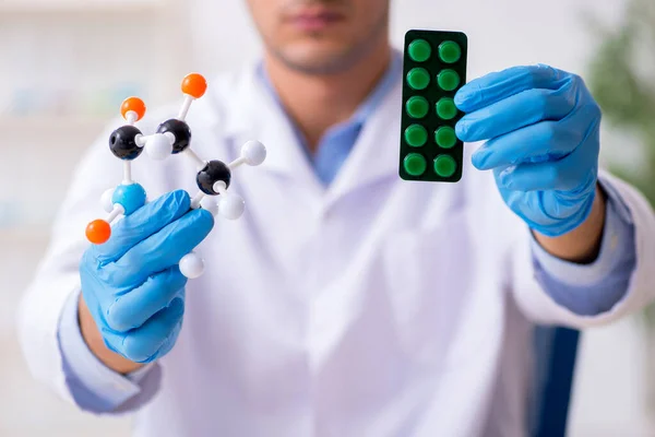 Jovem assistente de laboratório no conceito de síntese de drogas — Fotografia de Stock