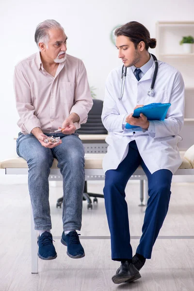 Joven médico masculino y paciente de edad avanzada en concepto antitabaco — Foto de Stock