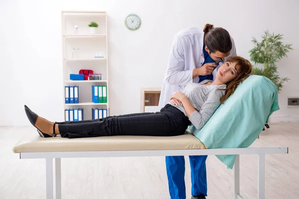 Jovem mulher visting jovem médico masculino otorrinolaringologista — Fotografia de Stock