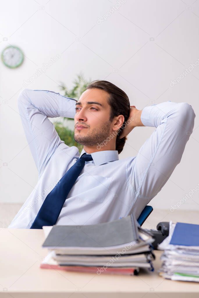 Young male businessman employee unhappy with excessive work