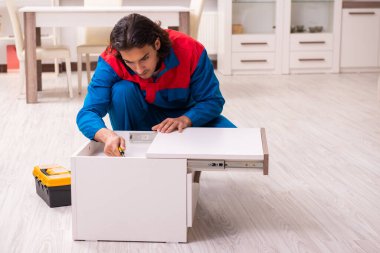 Genç erkek marangoz içeride çalışıyor.