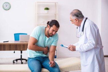 Yaralı genç adam yaşlı doktoru ziyaret ediyor.