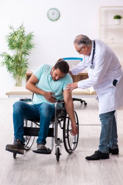 Tecrübeli doktor ve tekerlekli sandalyedeki genç hasta.
