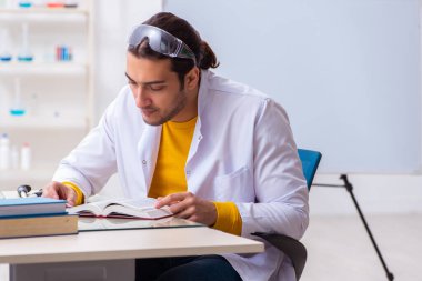 Genç erkek kimyager sınava hazırlanıyor.