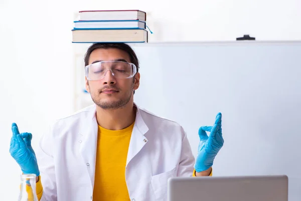 Young male chemist student preparing for exam — Stock Photo, Image