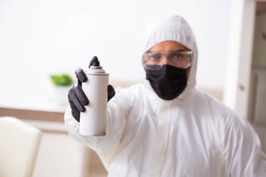 Genç erkek müteahhit evde haşere kontrolü yapıyor.