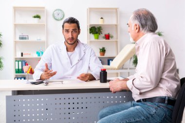 Yaşlı adam genç doktor kardiyoloğu ziyaret ediyor.