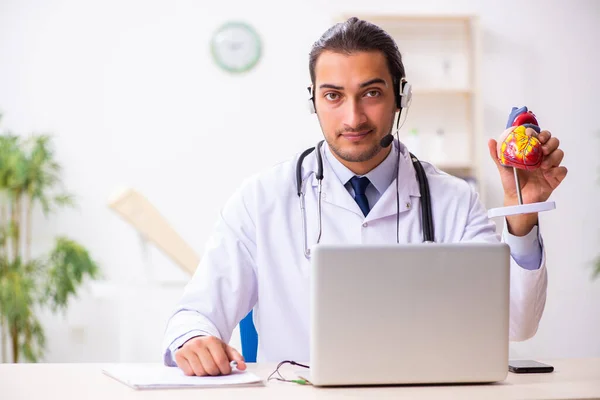 Junger Arzt hört Patient während telemedizinischer Sitzung zu — Stockfoto