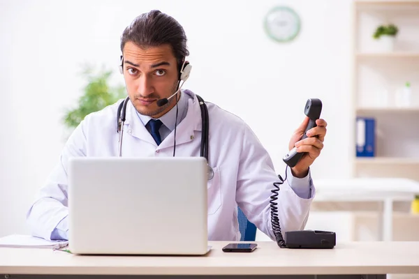 Jonge arts luistert naar patiënt tijdens telegeneeskundesessie — Stockfoto