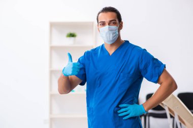 Klinikte çalışan genç erkek doktor.