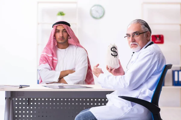 Young male arab visiting experienced male doctor — Stok fotoğraf