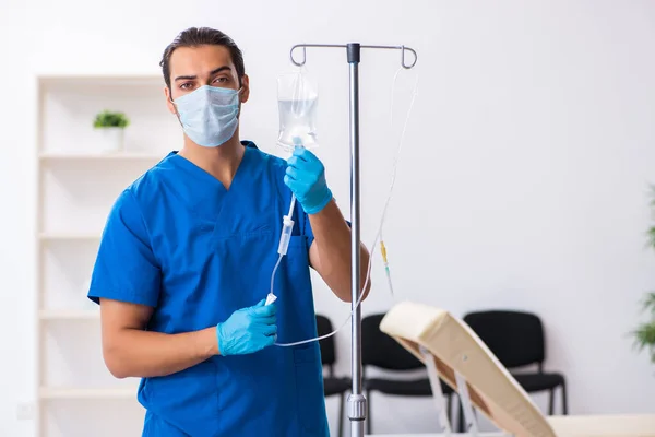 Ung manlig läkare som arbetar på kliniken — Stockfoto